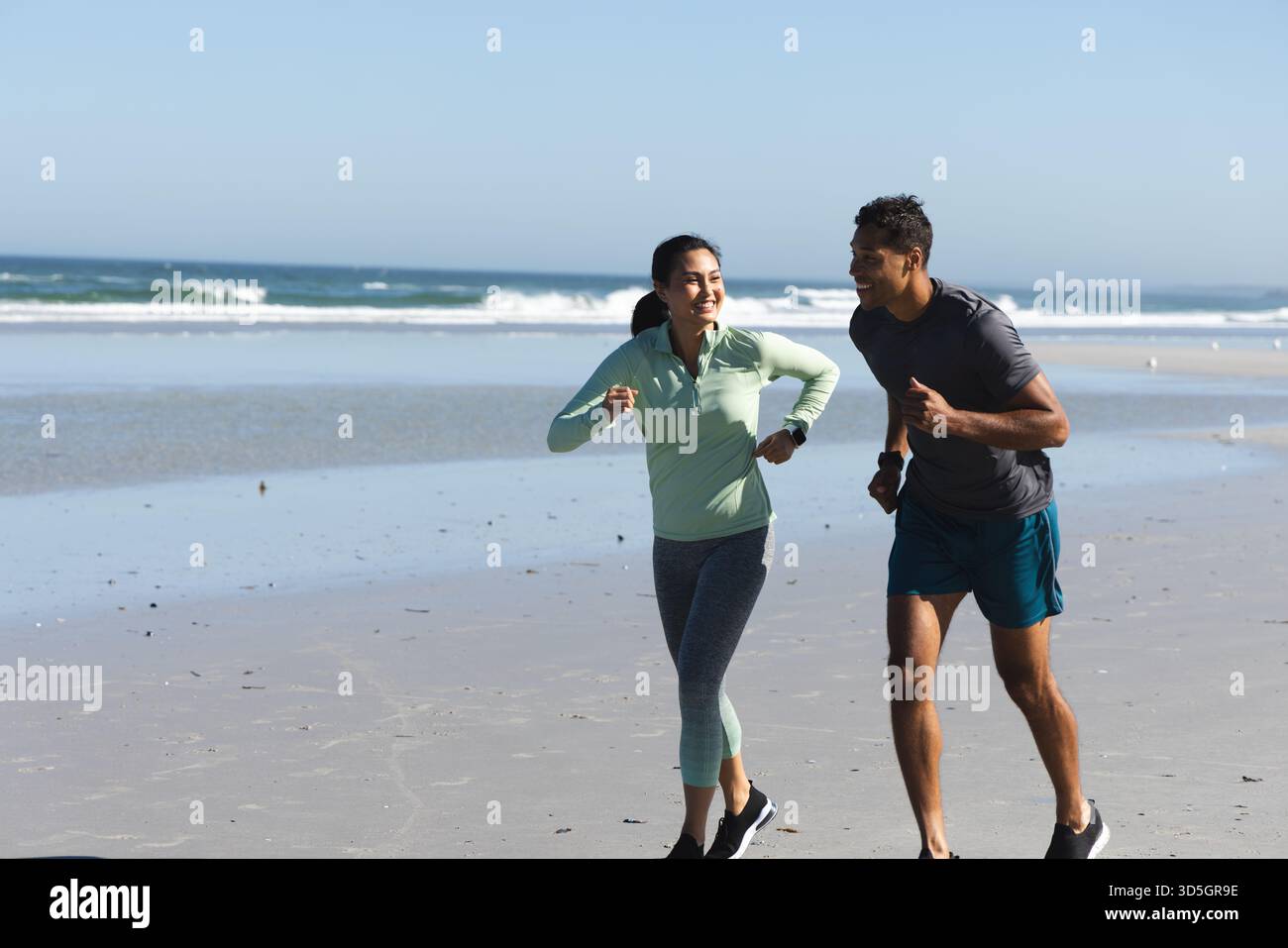 Jogging sulla spiaggia, coppie che si allenano sull'oceano durante la routine di allenamento mattutina, spazio per fotocopie Foto Stock