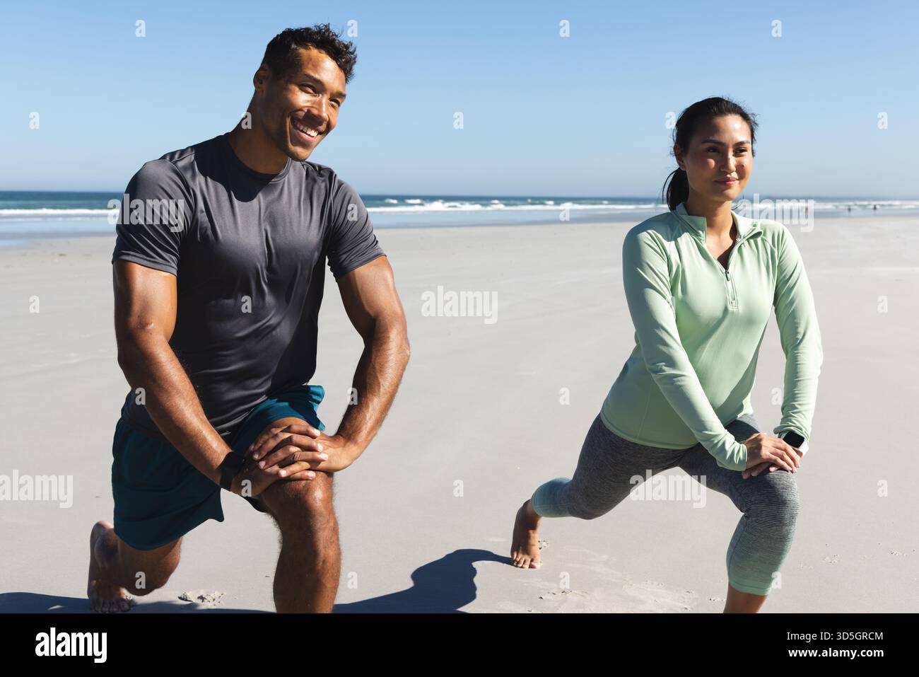 In coppia si allenano sulla spiaggia, si allungano le gambe e si allenano al mattino Foto Stock