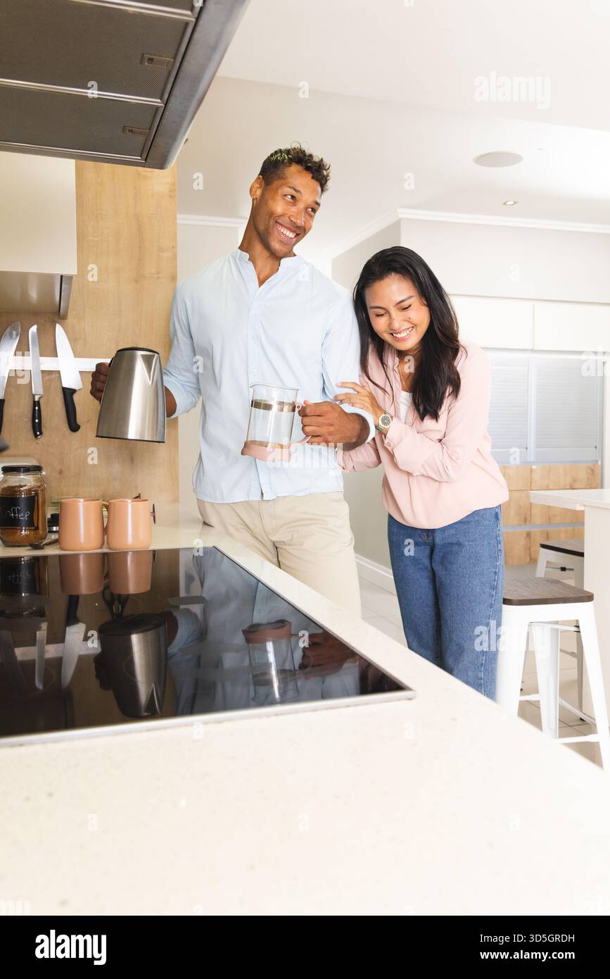 Coppia in cucina per preparare il caffè mattutino, sorridere e divertirsi insieme Foto Stock