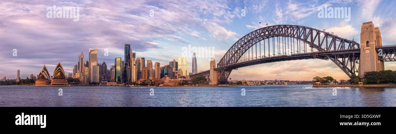 Fronte mare dei principali monumenti architettonici del CBD della città di Sydney con luce soffusa al mattino attraverso il porto. Foto Stock