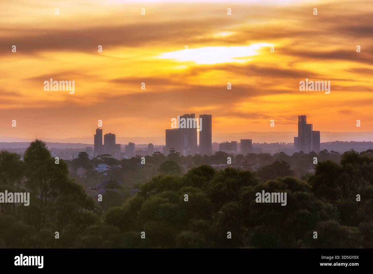 Alte torri commerciali di media distanza del CBD di Parramatta al tramonto, il suggestivo cielo arancione in Australia. Foto Stock