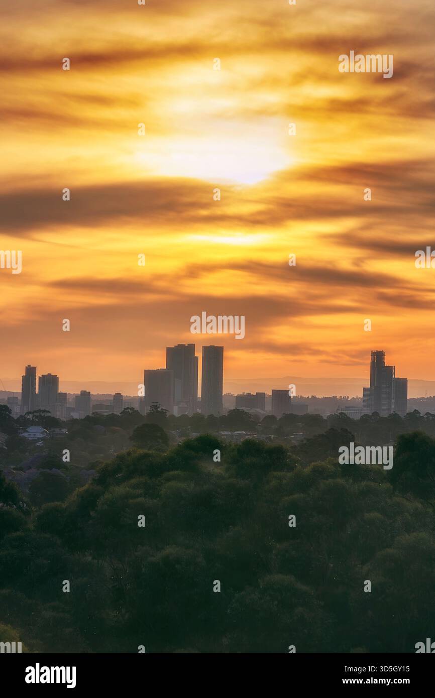 Lontane vedute delle alte torri commerciali del CBD di Parramatta al tramonto, il suggestivo cielo arancione in Australia. Foto Stock