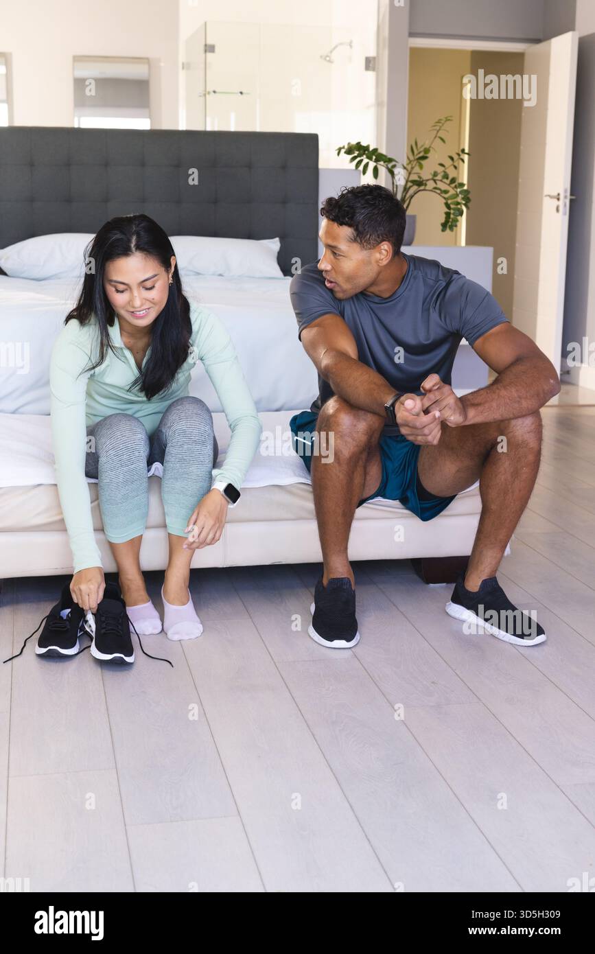 La coppia si prepara per l'allenamento mattutino a casa, legando le scarpe e chiacchierando Foto Stock