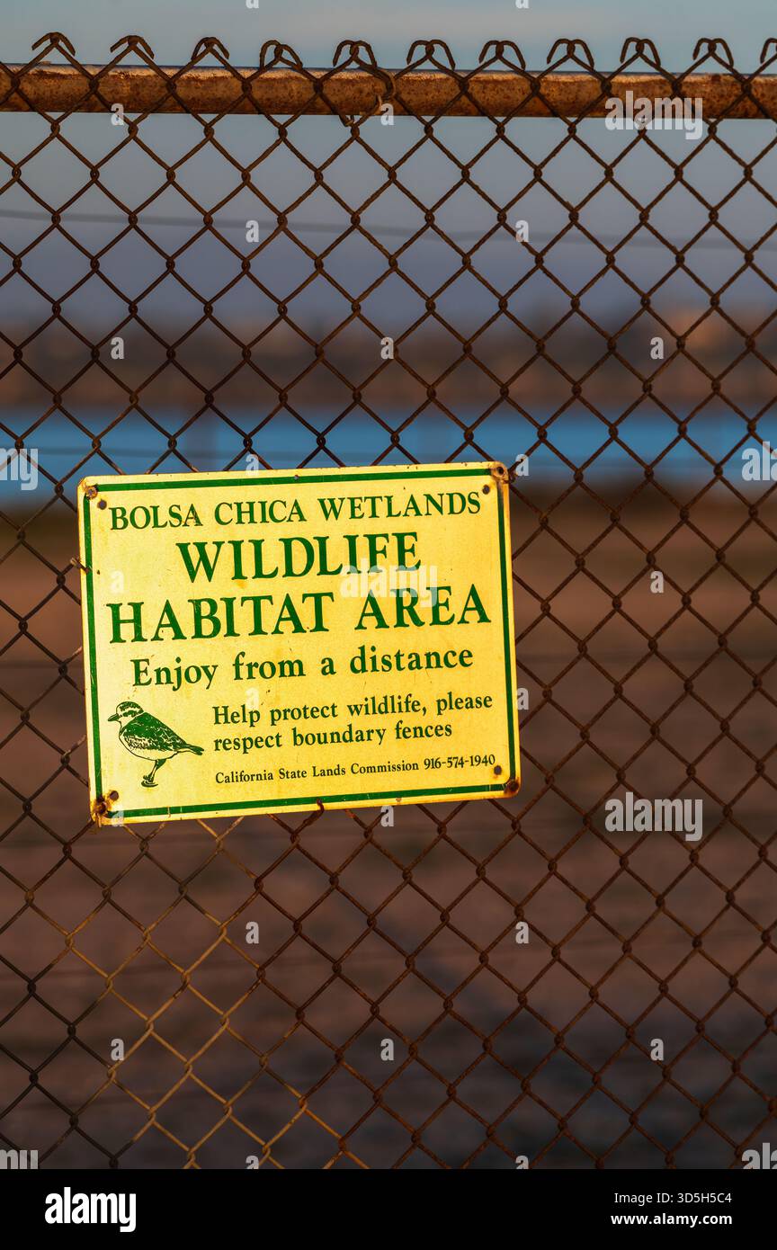 Un cartello con l'habitat naturale è apposto su una recinzione a catena a Bolsa Chica Wetlands a Huntington Beach, California. Credito: Erik Morgan Foto Stock