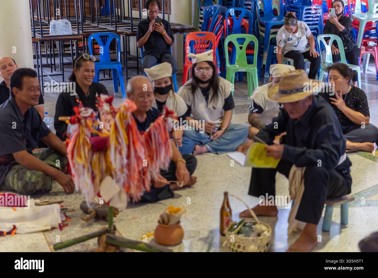 Suphanburi, Tailandia - 7 novembre 2025 : partecipanti a un rituale funerario della diga Song Thai, che esegue la cerimonia di richiamo dello spirito figure artigianali e t Foto Stock
