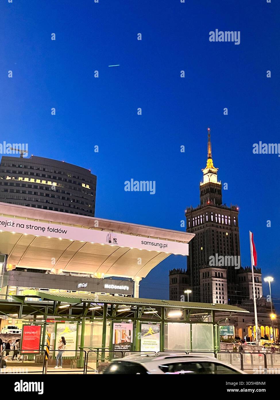 Paesaggio urbano serale del centro di Varsavia con moderne infrastrutture di trasporto e l'iconico skyline illuminato dopo il tramonto. Viaggi urbani, architettura, - Immagine stock catturata con smartphone