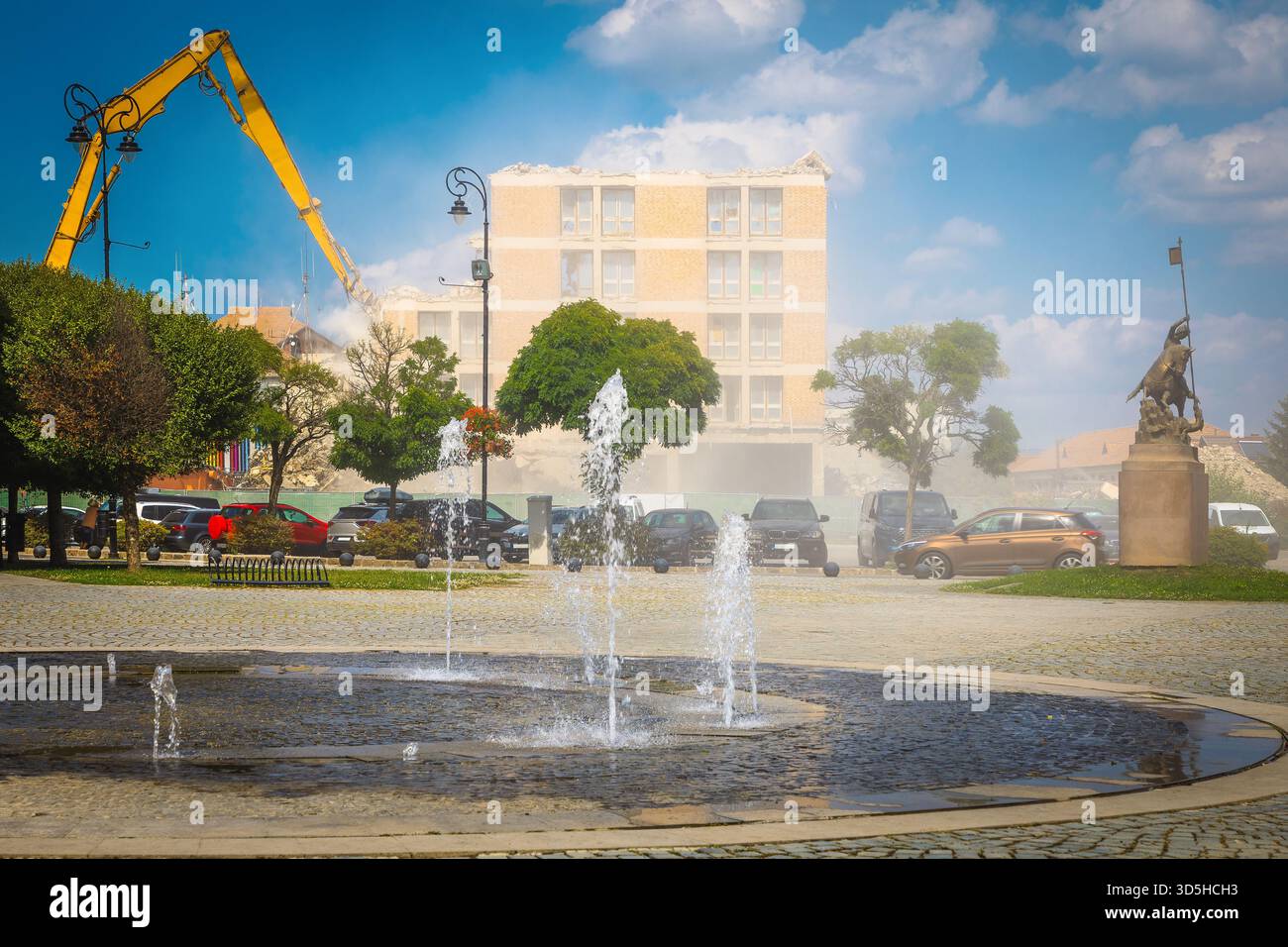 Spettacolare demolizione polverosa di un vecchio grattacielo in rovina nel centro della città utilizzando cesoie idrauliche da costruzione Foto Stock