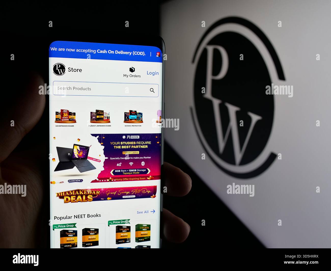 In questa illustrazione fotografica, una persona ha in mano un cellulare con la pagina web della società indiana Physics Wallah Limited (PW) sullo schermo davanti al logo. (Foto di Timon Schneider / SOPA Images/Sipa USA) *** esclusivamente per notizie editoriali *** Foto Stock