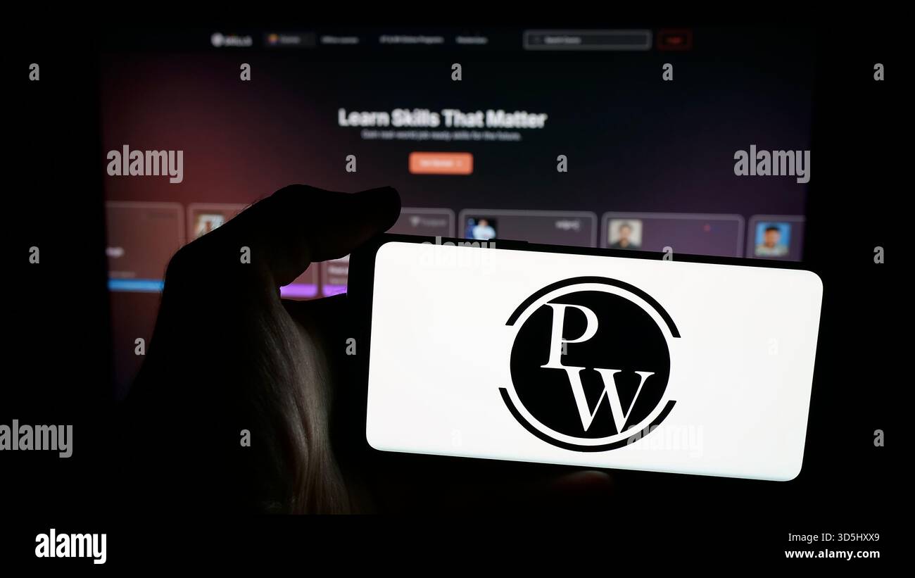 In questa illustrazione fotografica, una persona ha in mano un telefono cellulare con il logo della società indiana Physics Wallah Limited (PW) sullo schermo davanti alla pagina web. (Foto di Timon Schneider / SOPA Images/Sipa USA) *** esclusivamente per notizie editoriali *** Foto Stock