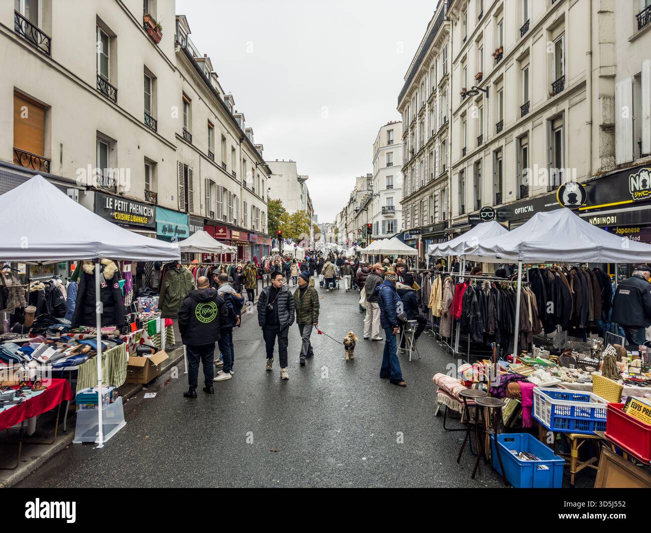 Francia, Parigi, 17 novembre 2024; persone che camminano e fanno shopping in un mercato all'aperto in una giornata nuvolosa a parigi in via Oberkampf, Parigi, 75011 Foto Stock