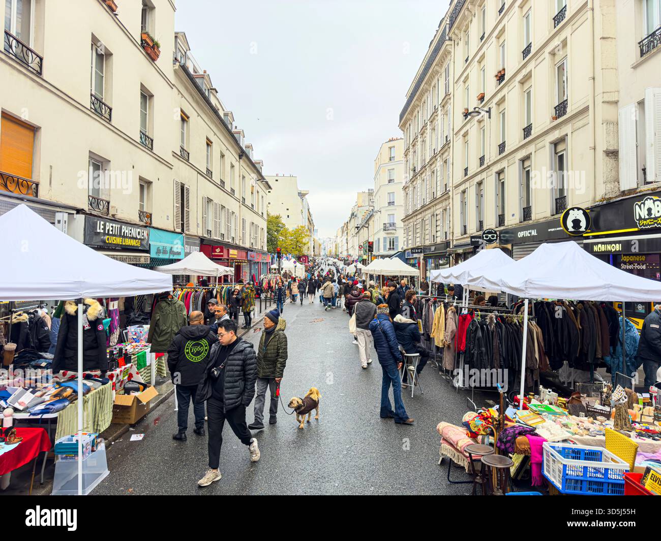 Francia, Parigi, 17 novembre 2024; persone che camminano e fanno shopping in un mercato all'aperto in una giornata nuvolosa a parigi in via Oberkampf, Parigi, 75011 Foto Stock