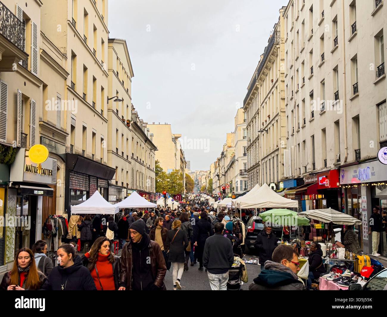 Francia, Parigi, 17 novembre 2024; persone che camminano e fanno shopping in un mercato all'aperto in una giornata nuvolosa a parigi in via Oberkampf, Parigi, 75011 Foto Stock