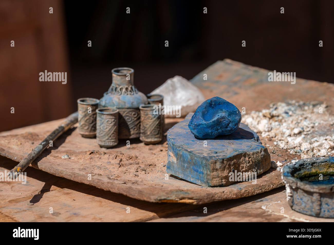 Pigmento indaco e strumenti tradizionali utilizzati nella pittura marocchina. Pietra indaco grezza e materiali artigianali sul tavolo da lavoro di un artista in Marocco. Foto Stock