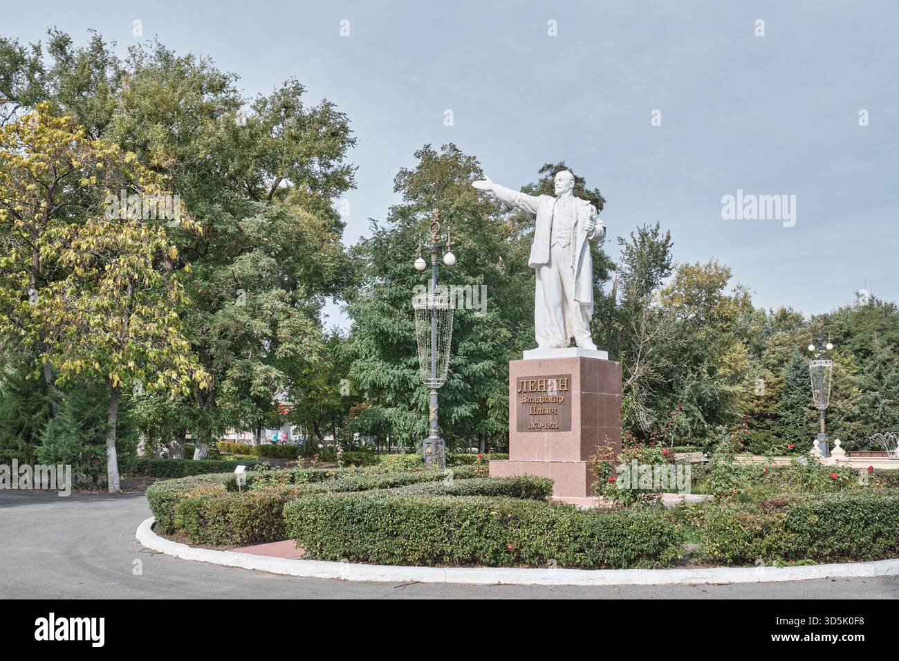 Volgograd, Russia - 5 ottobre 2025: Statua di pietra bianca di Vladimir Lenin, in piedi su un alto piedistallo rosso, situato nel parco di Pyatimorsk. Surro Foto Stock