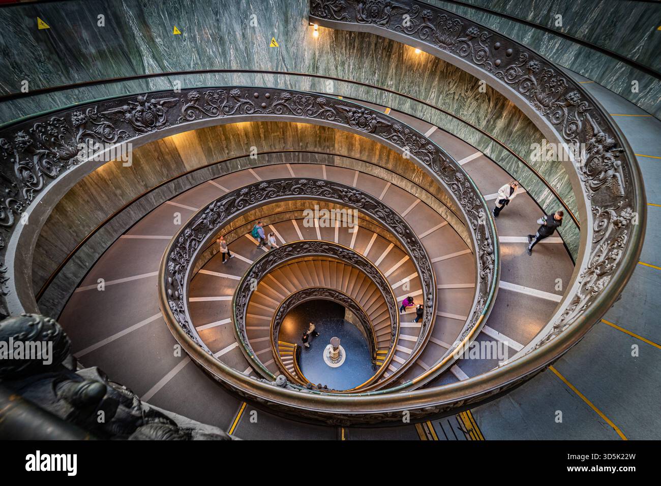Vista dall'alto verso il basso della doppia scala a chiocciola Momo, con curve eleganti, motivi geometrici e simmetria nell'architettura moderna degli interni, Italia. Foto Stock