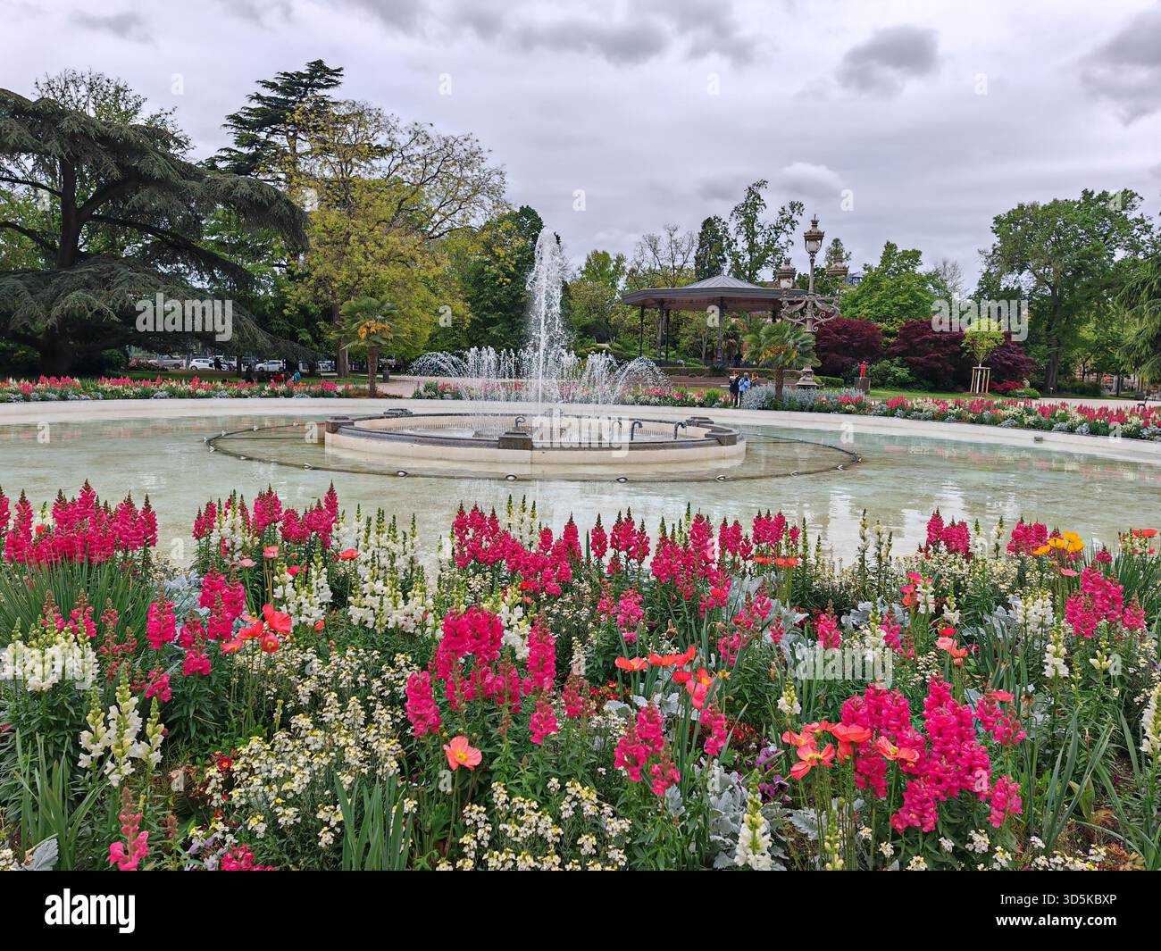 Colorato giardino di fiori con fontana nel parco pubblico Foto Stock