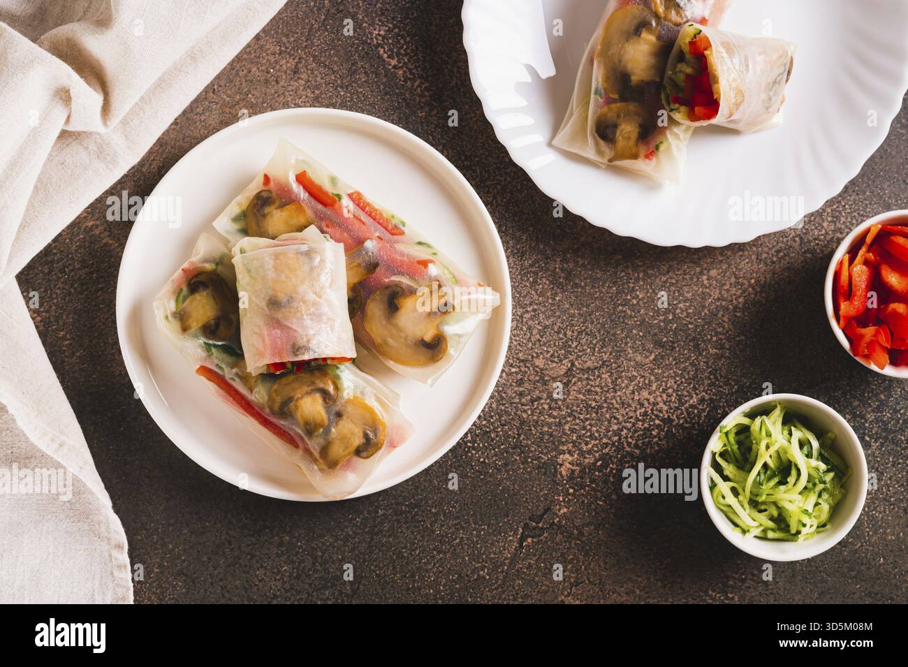 Involtini primaverili vegetariani con cetriolo, pepe e funghi fritti su un piatto con vista dall'alto Foto Stock