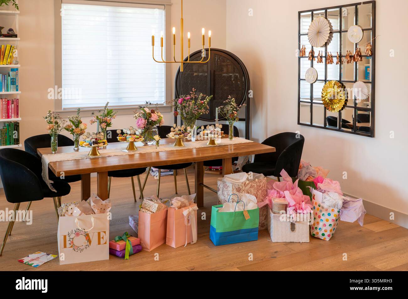 Accogliente tavolo da pranzo per feste casalinghe con regali, fiori e decorazioni natalizie per amici e familiari Foto Stock
