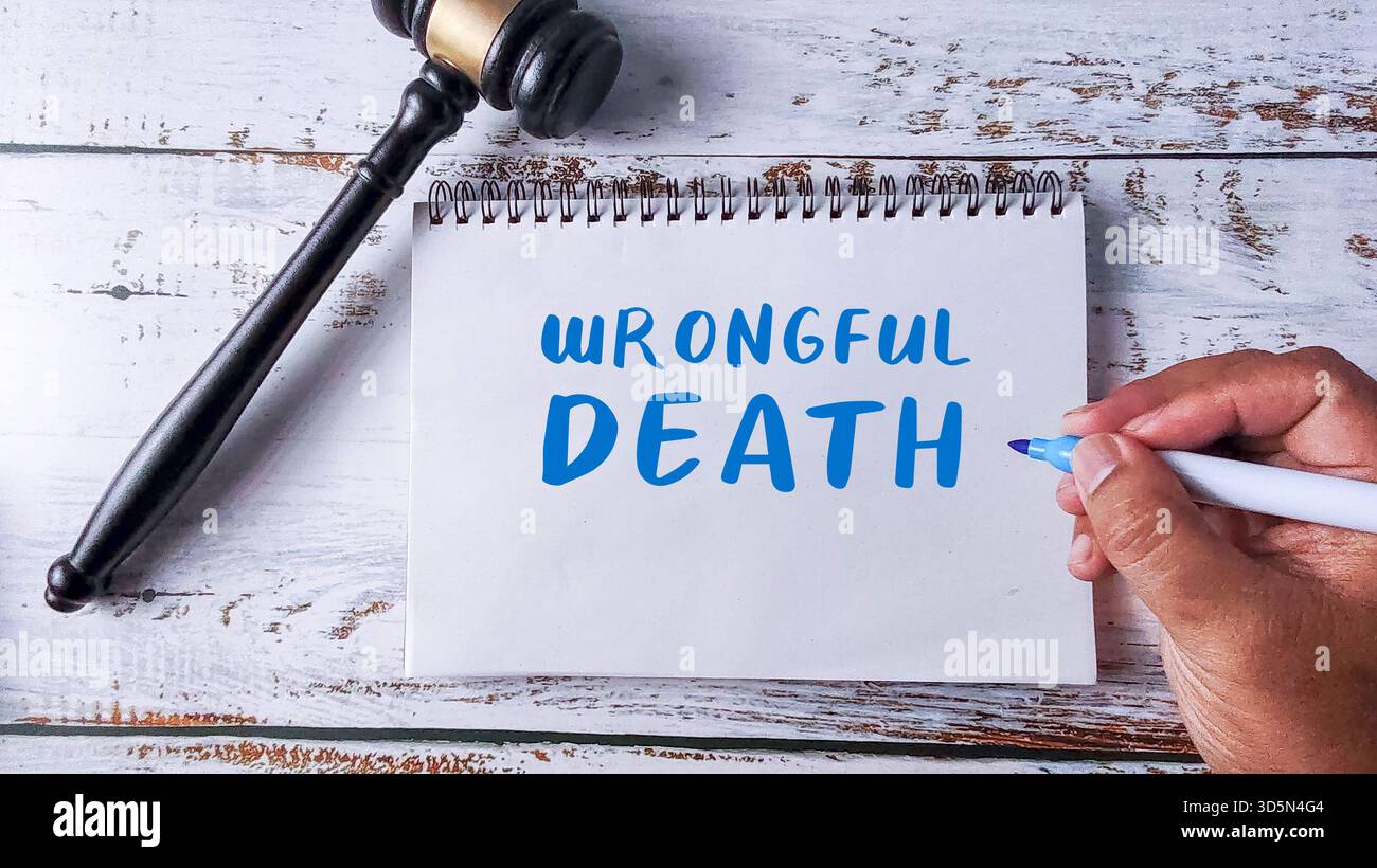 Scrittura a mano "morte illecita" in un quaderno accanto a un martelletto, simbolo di rivendicazione legale, legge TORT e caso di risarcimento Foto Stock