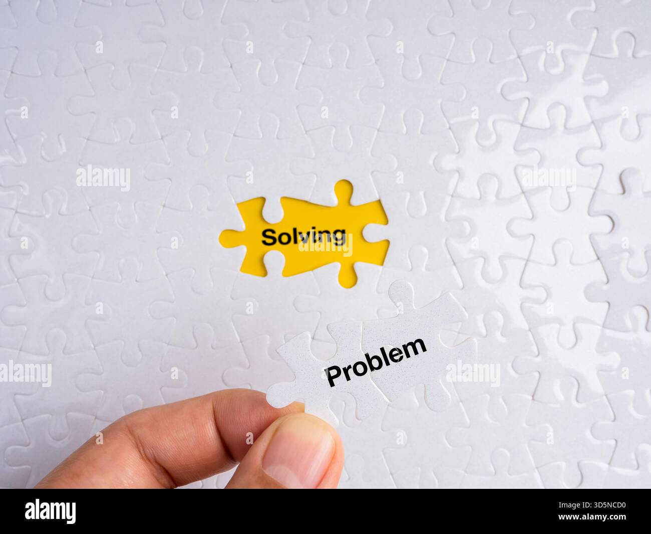 Mano posizionando un pezzo bianco del puzzle etichettato "problema" in un punto giallo mancante che rivela la parola "risoluzione". Concetto di risoluzione dei problemi, strategia, log Foto Stock