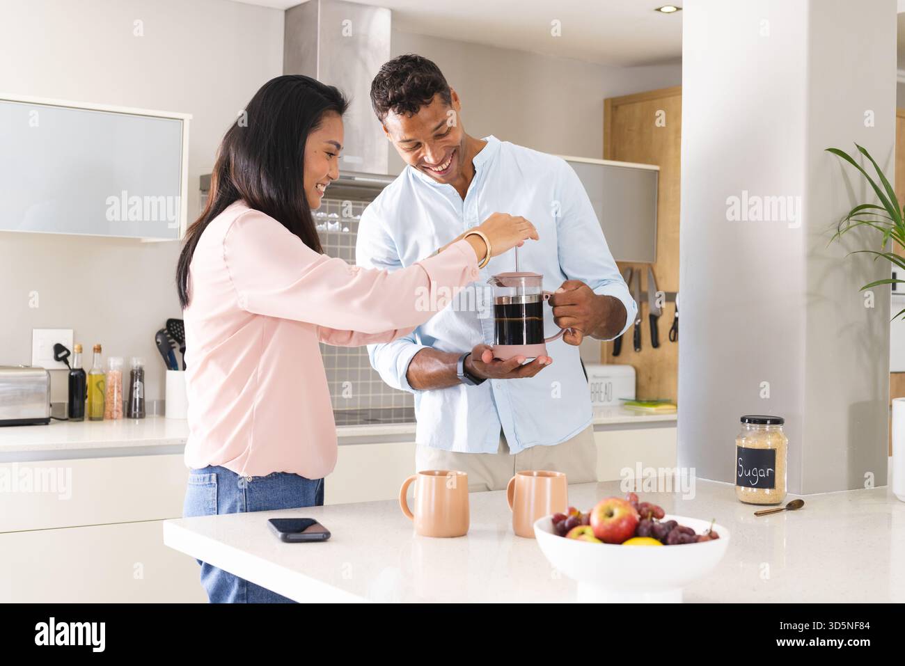 Abbinatevi a preparare il caffè in cucina moderna, godendovi la routine mattutina Foto Stock
