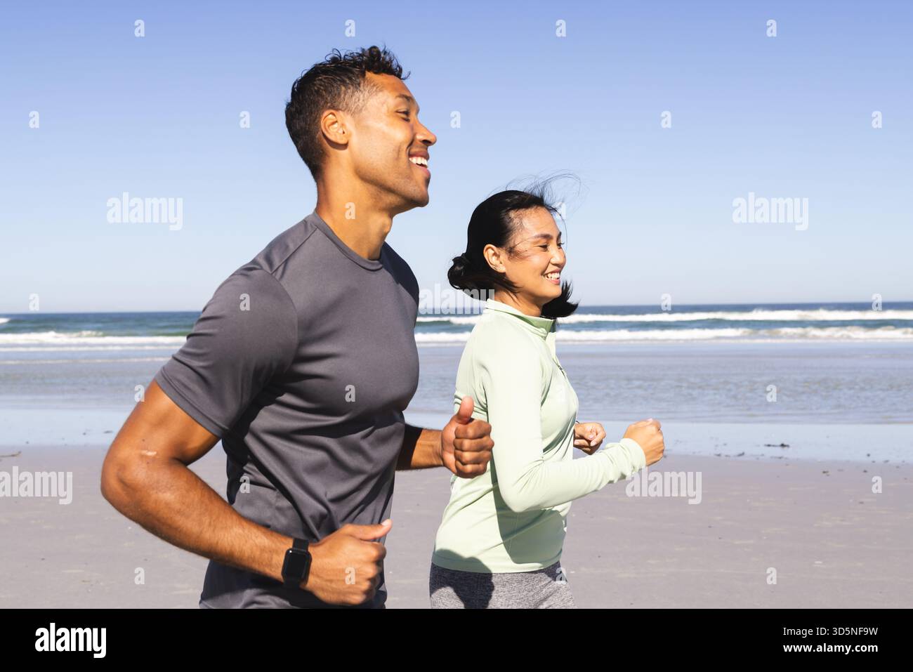 Coppia che fa jogging sulla spiaggia, si fa esercizio mattutino e si respira la fresca brezza dell'oceano Foto Stock