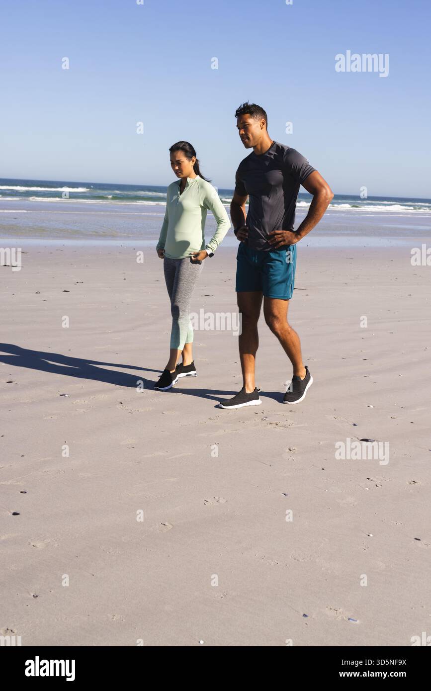 Passeggiate sulla spiaggia sull'oceano, coppie che si allenano insieme la mattina Foto Stock