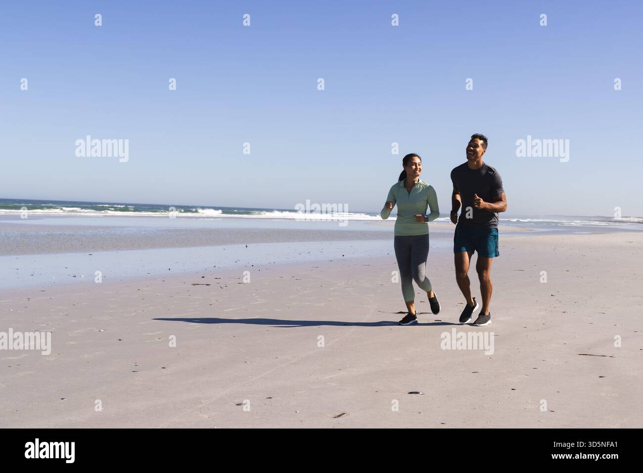 Coppia che fa jogging sulla spiaggia, si gode una giornata di sole e si mantiene attivi insieme, copia spazio Foto Stock
