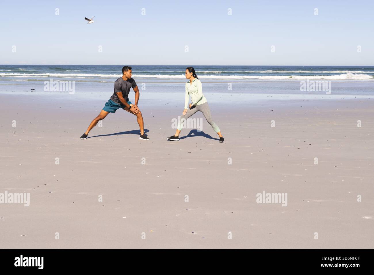 Coppia che si allenano sulla spiaggia, si allungano e si allenano all'oceano, e si copia spazio Foto Stock