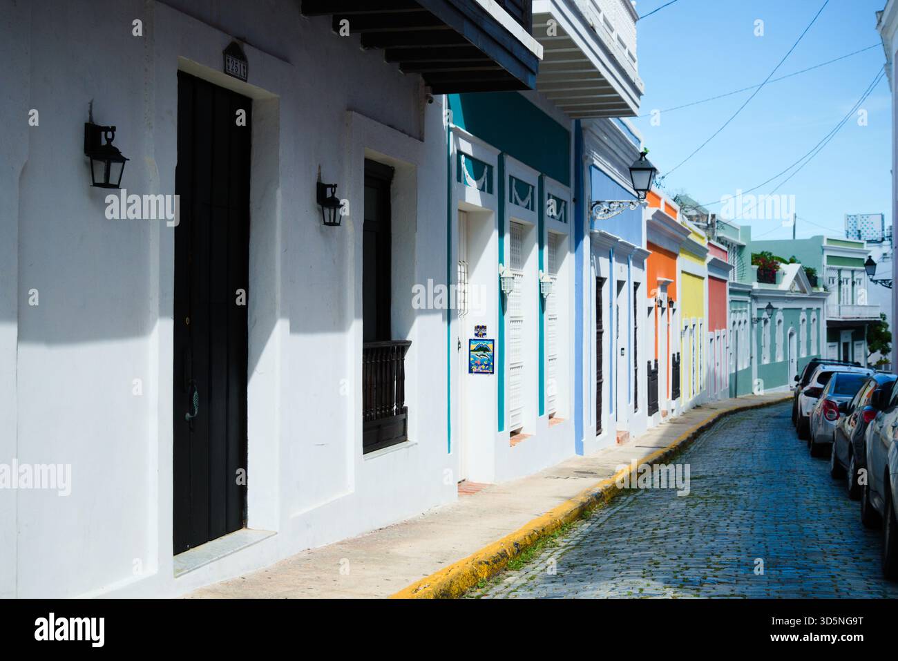 Una stretta strada acciottolata e' fiancheggiata da edifici colorati, ognuno caratterizzato da porte e finestre uniche. Foto Stock