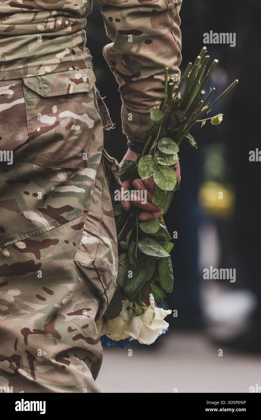 Onorare la memoria dei compagni caduti. Esercito ucraino. Ricordo dei morti. Guerra russo-Ucraina. Soldati ucraini. Fiori nella mano di un uomo. Foto Stock
