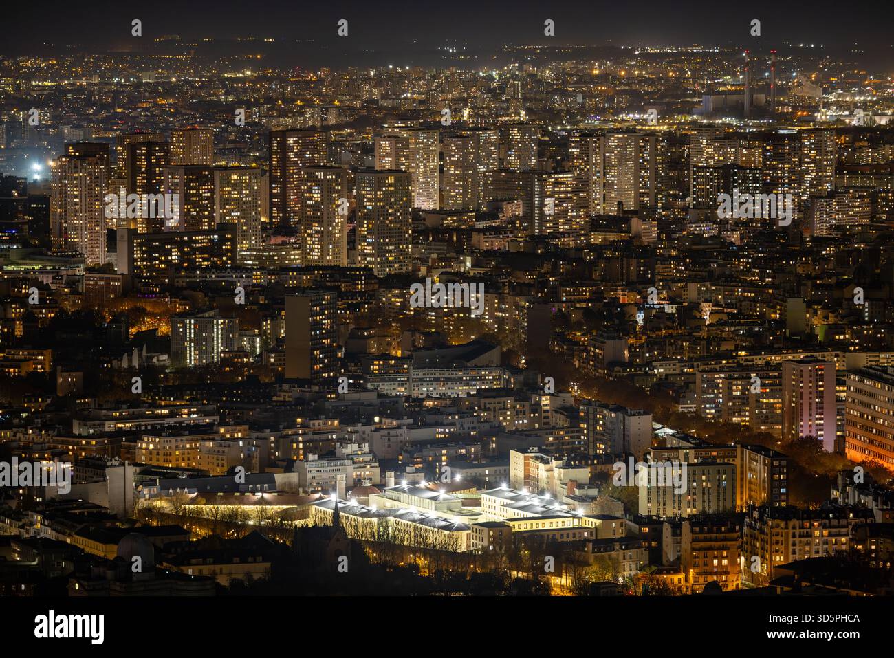 La vista aerea del paesaggio urbano illuminato rivela un arazzo di luci e ombre scintillanti, il vibrante bagliore che contrasta con il cielo oscuro, Parigi, il Foto Stock