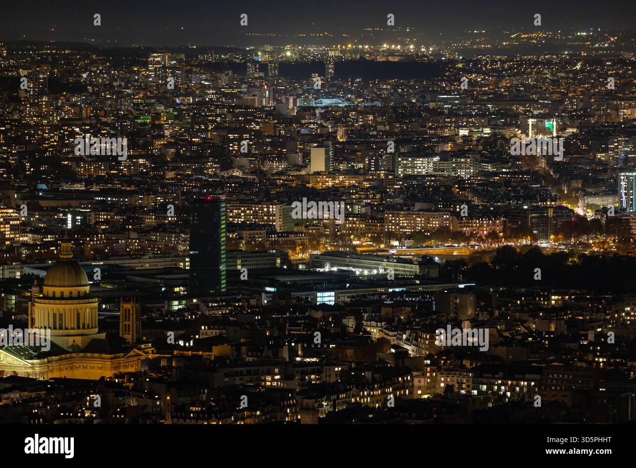 Vista aerea di uno scintillante arazzo di luci che illuminano la città, con la cupola del Pantheon e Tour Montparnasse che pierta il cielo notturno, Parigi, il Foto Stock
