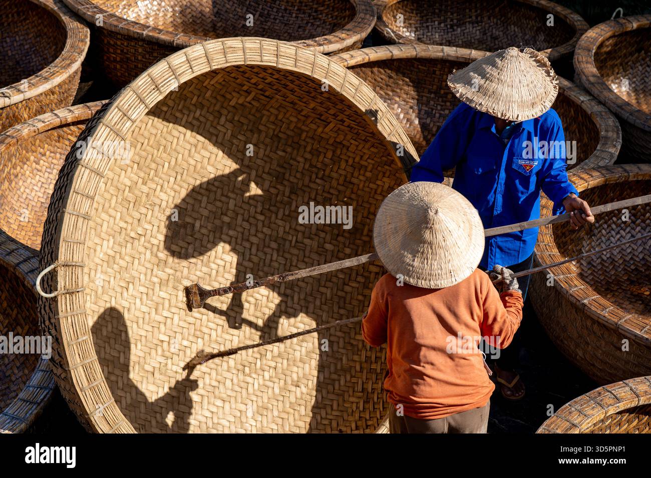 Vista aerea dei lavoratori che indossano cappelli tradizionali, circondati da cesti intrecciati, le texture e le ombre creano una scena accattivante, ho chi Minh City, H. Foto Stock