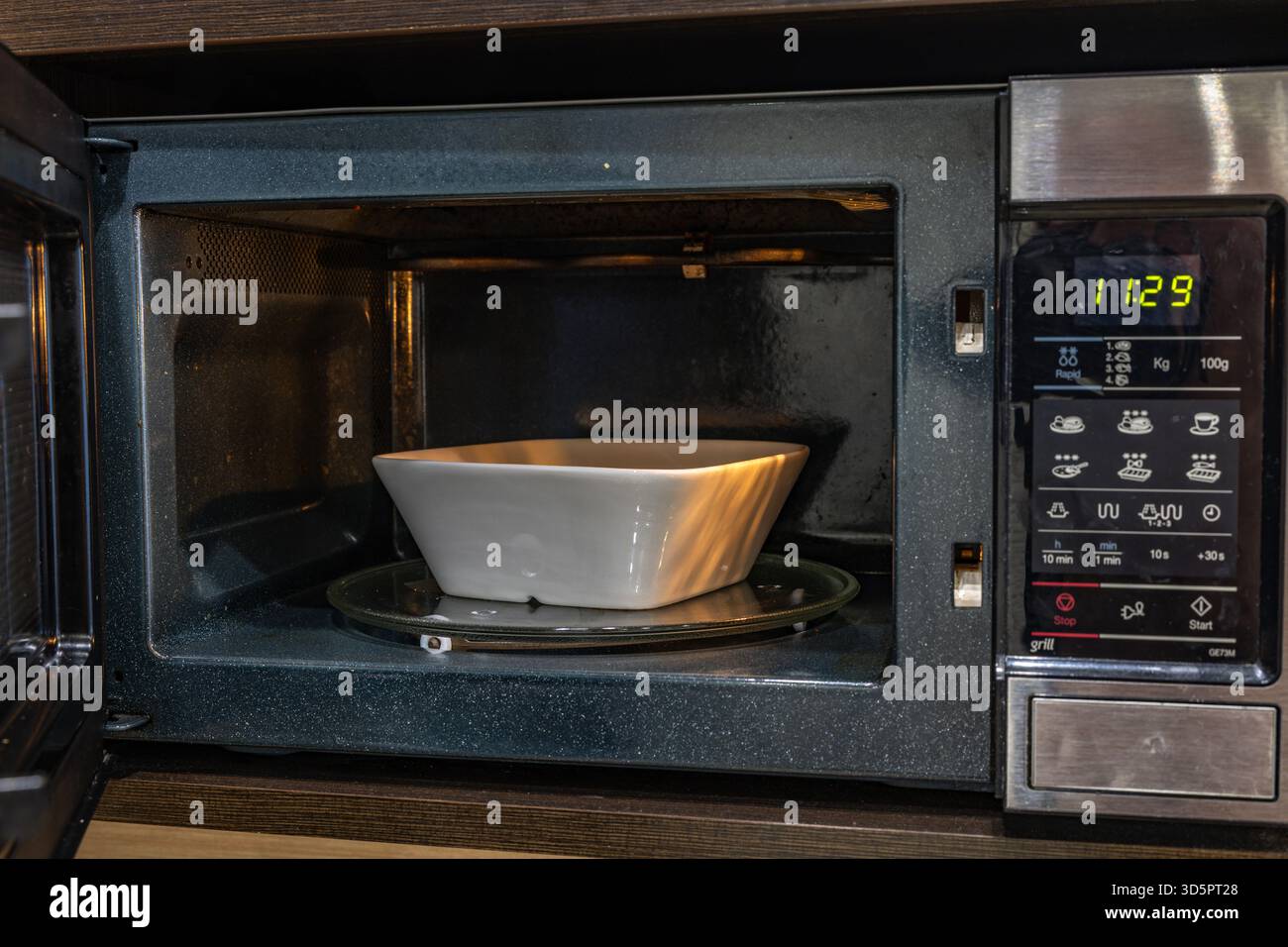 Microonde aperto per preparare un pasto veloce per la cena Foto Stock
