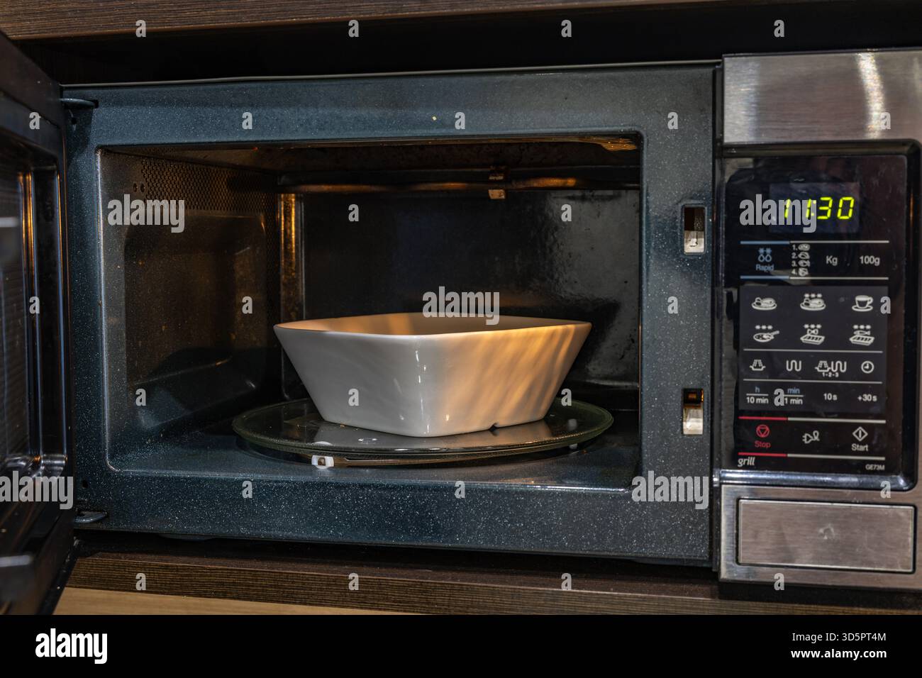 Microonde aperto per preparare un pasto veloce per la cena Foto Stock