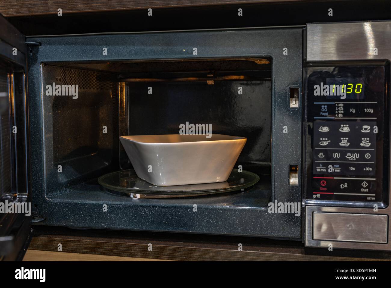 Microonde aperto per preparare un pasto veloce per la cena Foto Stock