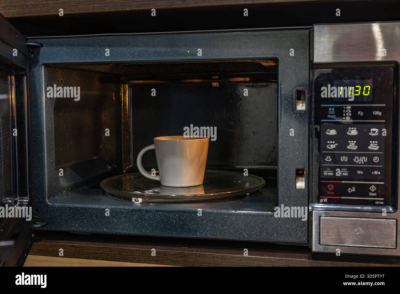 Microonde aperto per preparare un pasto veloce per la cena Foto Stock