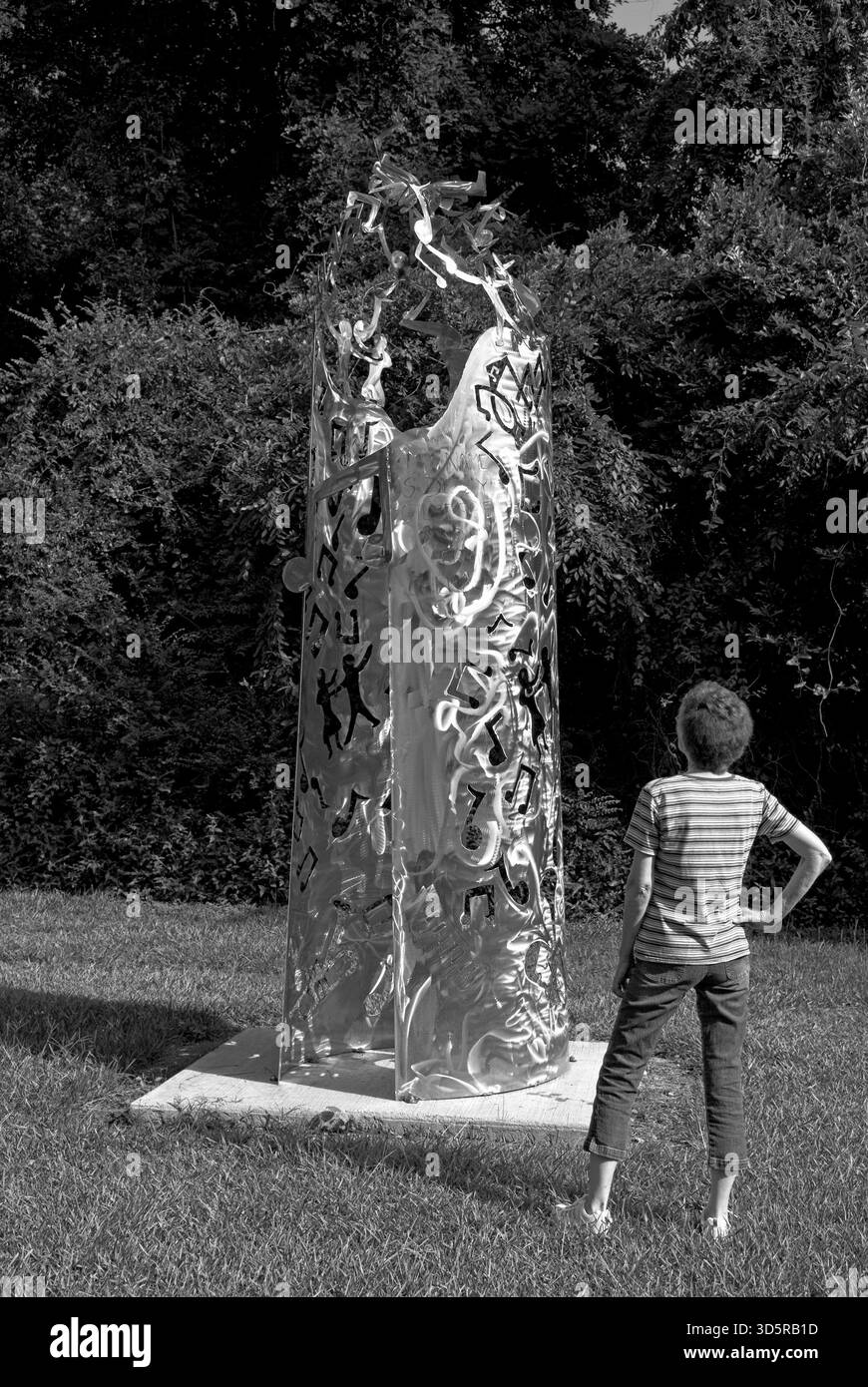 Donna caucasica che guarda una scultura a Dizzy Gillespie Park, Cheraw, South Carolina, Stati Uniti. Foto Stock