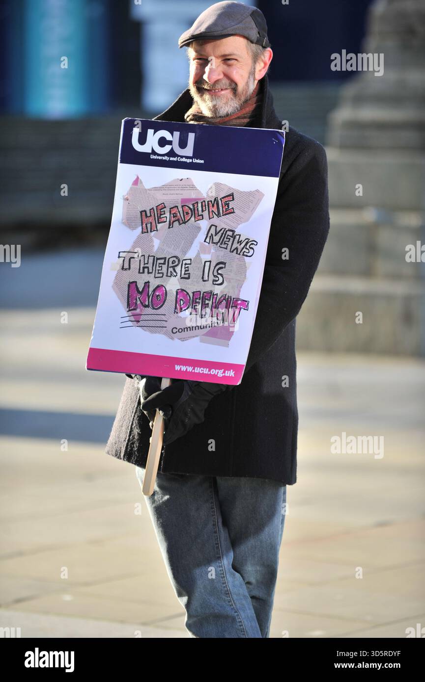 EDIMBURGO, SCOZIA – 17 novembre 2025: Manifestanti visti al picchetto con cartello. I membri della University and College Union (UCU) presso l'Università di Edimburgo sono solidali sulle linee di picchetto in importanti ingressi del campus durante gli orari di apertura di un'azione industriale di tre giorni che inizia il 17 novembre 2025 a Edimburgo, Scozia, protestando contro un'iniziativa di risparmio di 140 milioni di sterline che potrebbe portare a significative riduzioni del personale, cessazioni obbligatorie e modifiche ai termini di impiego. Le dimostrazioni si svolgono tra le 9:00 e le 12:00 in siti selezionati, con un'anticipazione chiave dell'incontro Foto Stock