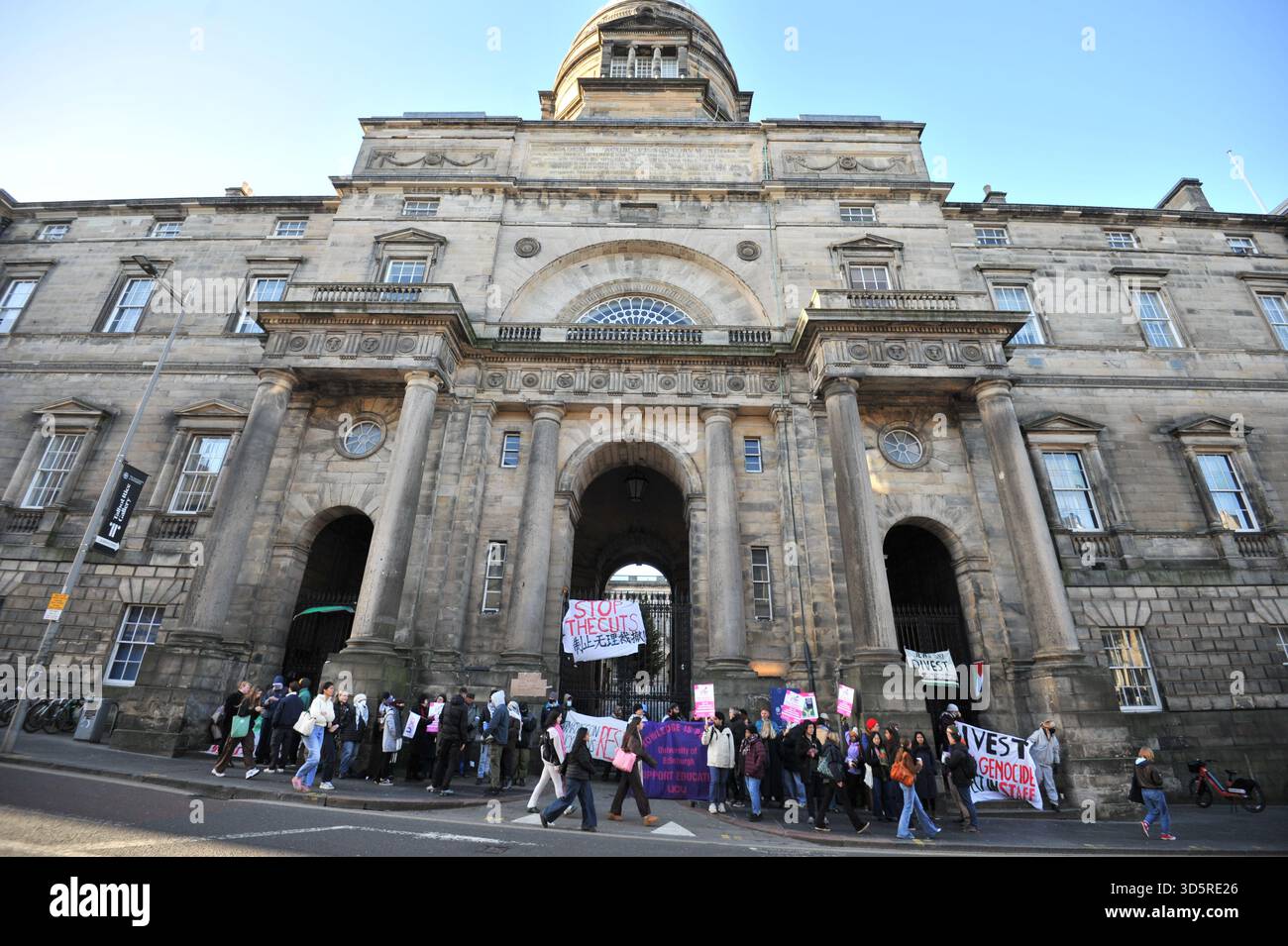 EDIMBURGO, SCOZIA – 17 novembre 2025: Visione generale dell'edificio con i manifestanti visti al picchetto con cartelli e striscioni i membri dell'Università e del College Union (UCU) dell'Università di Edimburgo sono solidali sulle linee di picchetto agli ingressi prominenti del campus durante gli orari di apertura di un'azione industriale di tre giorni che inizia il 17 novembre 2025 a Edimburgo, Scozia, protestando contro un'iniziativa di risparmio di £ 140 milioni che potrebbe portare a significative riduzioni del personale, terminazioni obbligatorie e modifiche ai termini di impiego. Le dimostrazioni si svolgono tra le 9:00 e le 12:00 a sele Foto Stock