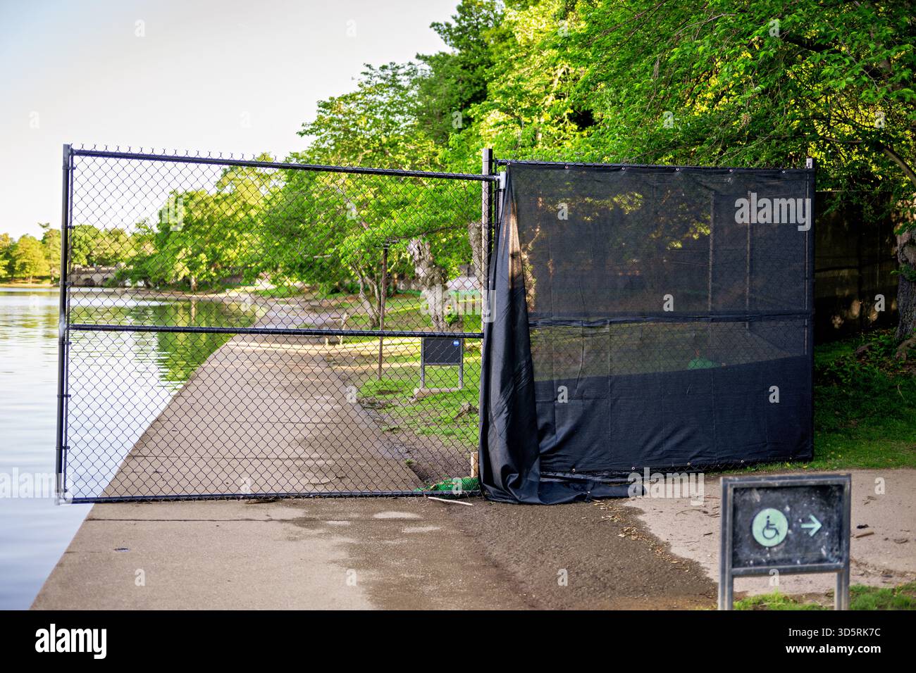 Tidal Basin Seawall Construction Project Setup Washington DC // WASHINGTON DC — Una recinzione a catena e una schermata nera per la privacy bloccano un percorso lungo il bacino Tidal, indicando la configurazione del progetto Tidal Basin Seawall Construction Project il 1° maggio 2024. Questo importante sforzo infrastrutturale sta riparando e innalzando le dighe che si deteriorano intorno all'iconico bacino delle maree di Washington DC. La costruzione mira a prevenire frequenti inondazioni, proteggendo monumenti come il Jefferson Memorial e i ciliegi giapponesi dall'innalzamento del livello del mare. Gestito dal National Park Service, questo progetto pluriennale assicura il Foto Stock
