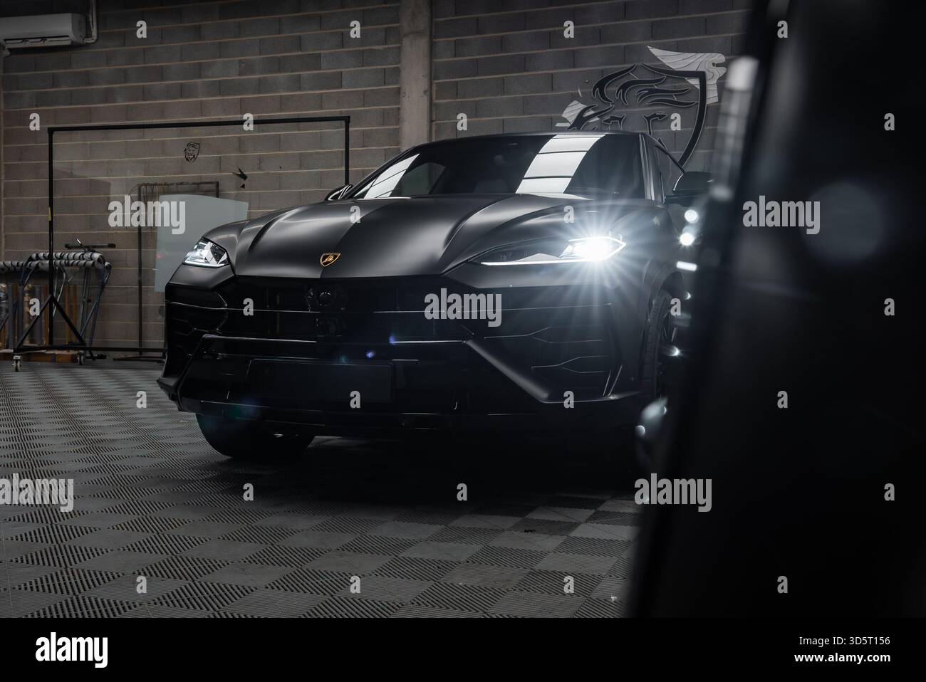 Lamborghini Urus nero opaco in un'officina moderna, testa ad angolo basso Foto Stock