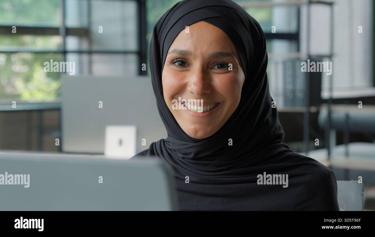 Felice positiva donna d'affari musulmana in hijab sorridente in ufficio araba etnica islamica imprenditrice donna lavoratrice ragazza sorridere toothy guardando la macchina fotografica Foto Stock