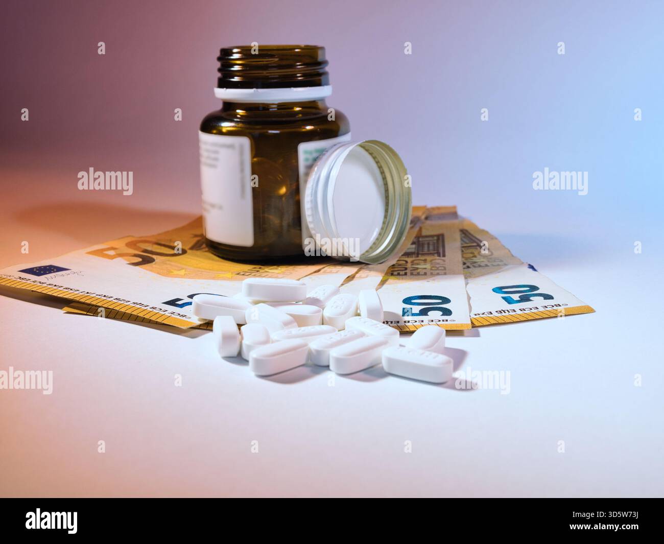 Costi farmaceutici: Pillole e euro - pillole da una bottiglia di medicinali con banconote da 50 euro, che simboleggiano l'alto costo dei farmaci e delle spese sanitarie Foto Stock