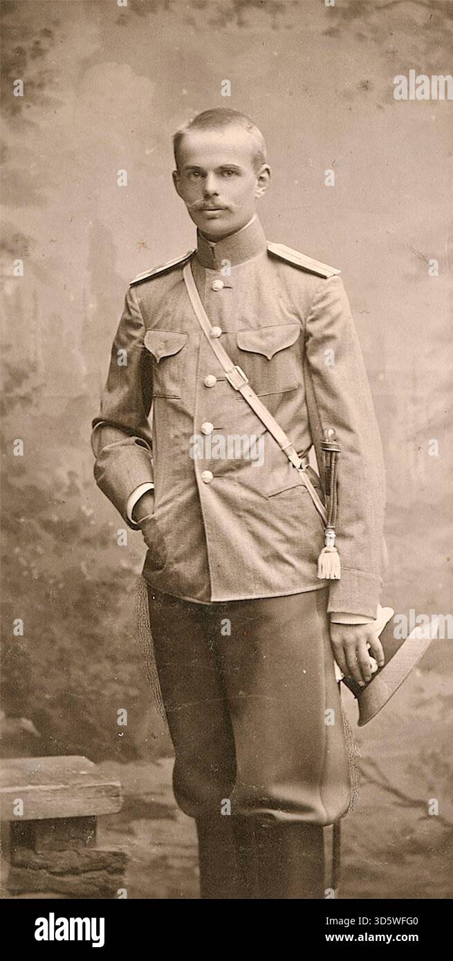 Barone Roman von Ungern-Sternberg nel ruolo di un giovane cadetto dell'esercito imperiale russo, scattato intorno al 1906 - la fotografia mostra un giovane uomo in piedi in uno studio, con indosso un'uniforme militare dai colori chiari. Indossa una tunica con un collare alto e spalline, tipica dell'esercito imperiale russo durante quell'epoca. Una cinghia bianca corre diagonalmente sul petto e un braccio laterale è appeso alla cintura sul lato destro. Il barone Ungern-Sternberg divenne in seguito un noto leader anti-bolscevico e signore della guerra durante la guerra civile russa, guadagnandosi i sobriquets "The Mad Baron" e "The Bloody Baron". Foto Stock