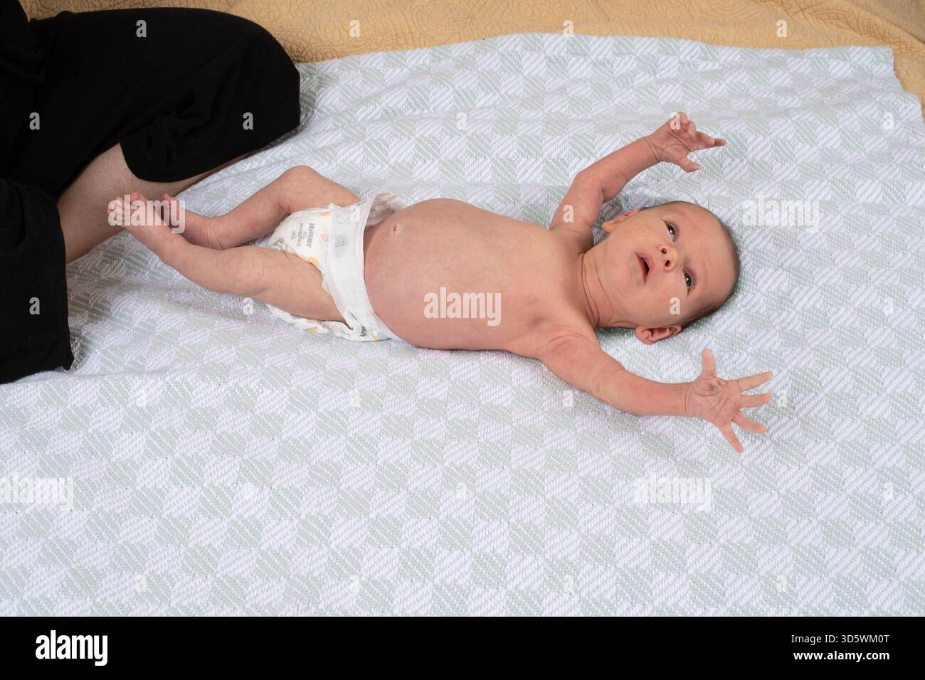 Neonato, bambino di 3 settimane sulla schiena con riflesso di startle Foto Stock
