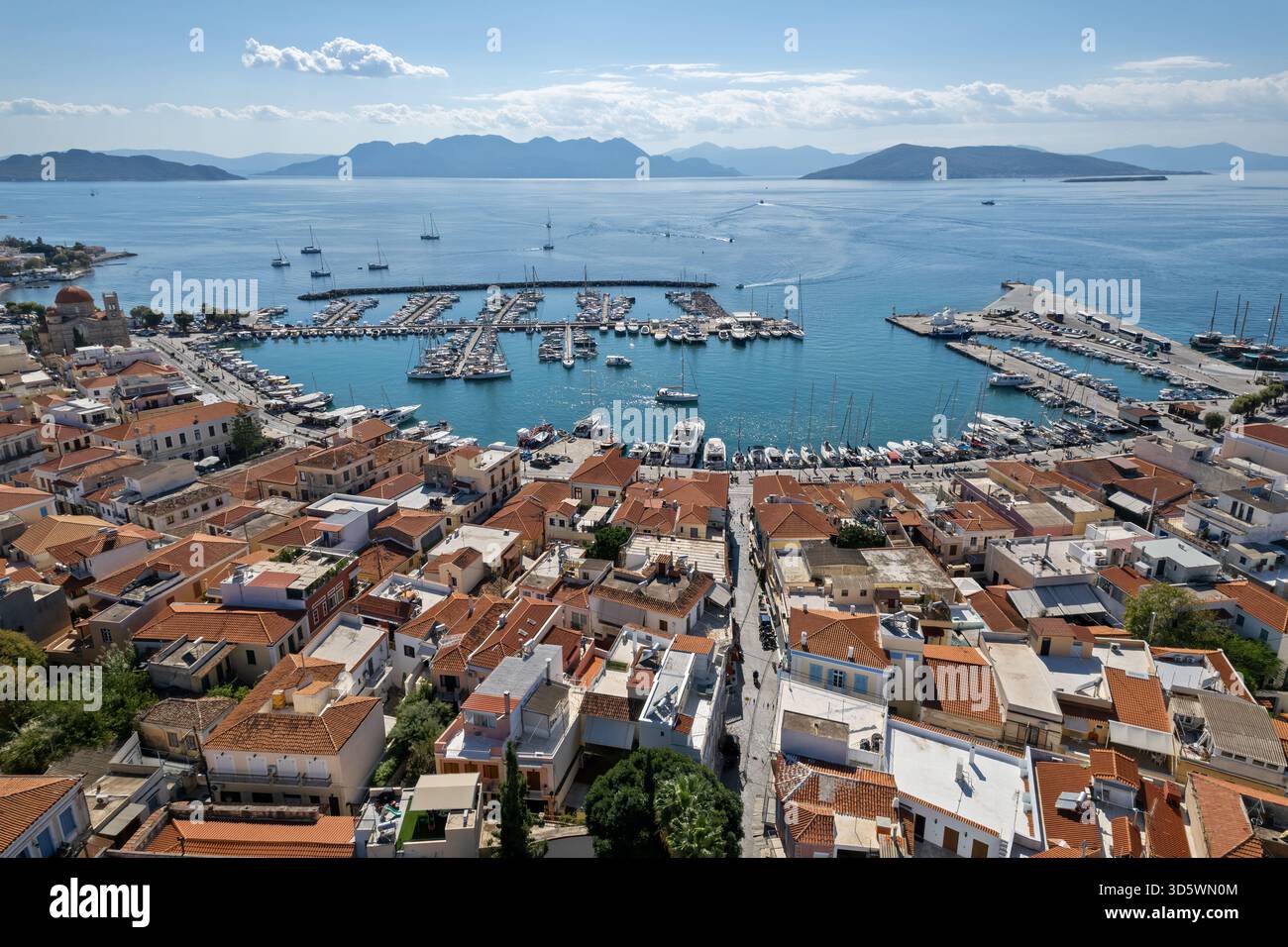 Vista aerea della città di Egina e del suo porticciolo in Grecia, con tetti in terracotta, barche a vela e le isole circostanti del Golfo Saronico. Foto Stock