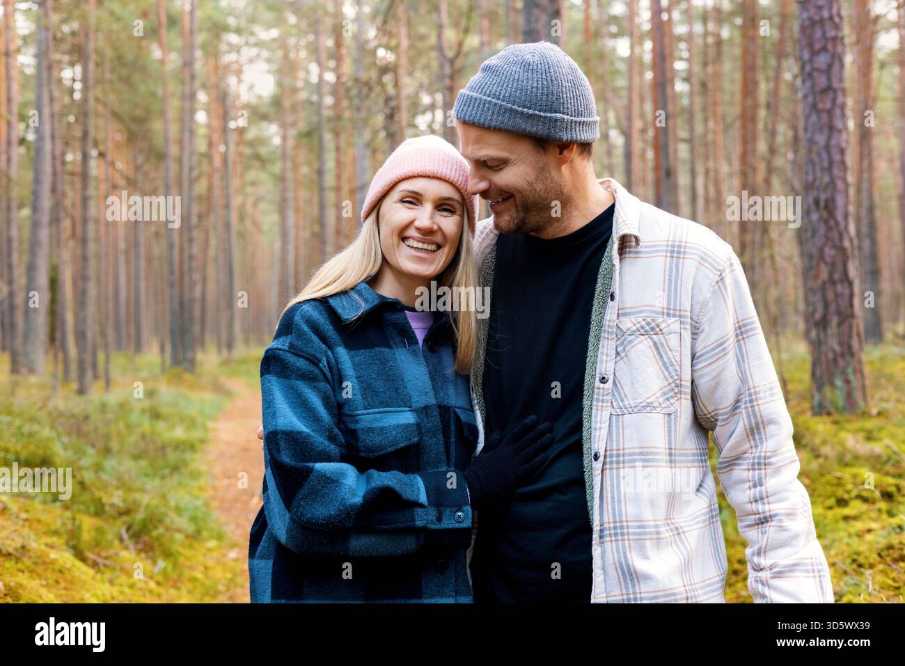 coppia felice innamorata che cammina nella foresta autunnale in un appuntamento romantico Foto Stock