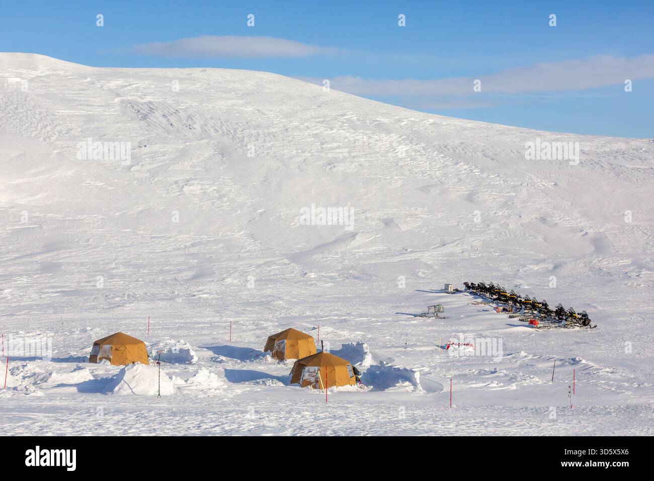 Motoslitte / motoslitte al campo di spedizione artico con tende protette da recinzioni a filo triplo contro gli orsi polari a Mohnbukta, Spitsbergen / Svalbard Foto Stock